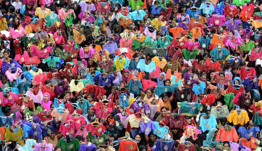 Indian students pose for photographers as they hold up painted and decorated blouses at a college in Chennai on October 9, 2015. Some 3,500 students painted 7,000 blouses in one hour on October 9 in an attempt to enter the Limca Book of Records. AFP PHOTO / STR (Photo credit should read STRDEL/AFP/Getty Images)