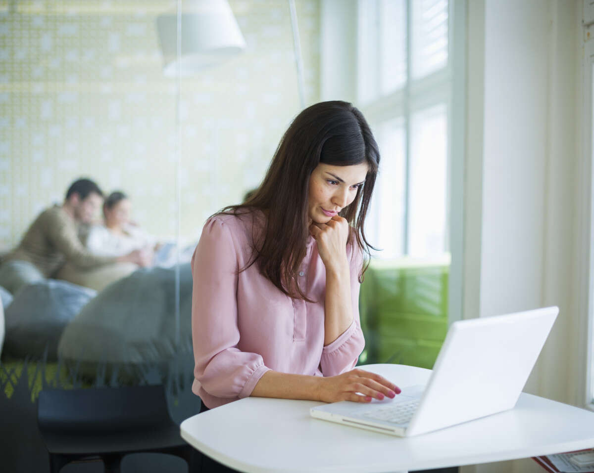 Young businesswoman using laptop at office table